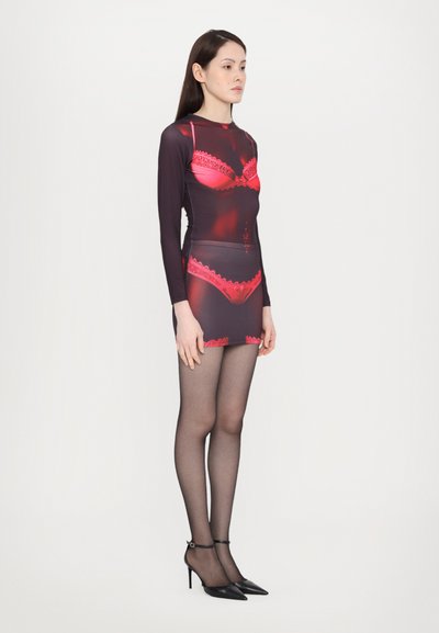 Lingerie-inspired bodysuit in black and red, featuring lace accents, long sleeves, and matching sheer black tights with pointed heels.