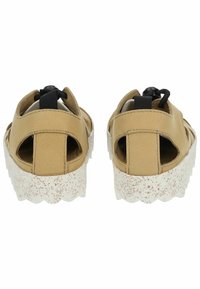 Kožené sandály v tan barvě s otevřenou patou, černým detailem ve tvaru smyčky a strukturální bílou podrážkou s tečkovaným vzorem. Design s kulatou špicí.