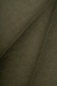 Olivgrüner Stoff mit einer strukturierten, gerippten Oberfläche. Das Material hat ein weiches, gewebtes Aussehen und einen subtilen Glanz, der Falten und Drapierungen zeigt.