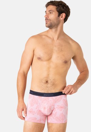 Boxer-briefs pour hommes de couleur rose avec un motif floral, dotés d'une taille sombre portant l'étiquette "Eminence" et d'une texture douce et extensible.