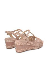 Sandales compensées rose clair avec un design en jute tressé, comportant plusieurs bandes croisées et des accents perforés pour la respirabilité.