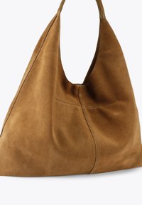 Borsa hobo in pelle scamosciata color cognac con design morbido, forma arrotondata e singolo cinturino per la spalla. Presenta cuciture visibili e una texture morbida.