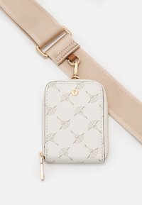 Portefeuille beige zippé en cuir texturé, avec un motif gaufré, des accessoires en or et une sangle attachée.