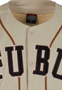 Maglia da baseball beige, perforata, con lettering "FUBU" in nero e marrone, chiusura a bottoni e piping marrone a contrasto sulle spalle.