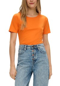 Oranje katoenen t-shirt met korte mouwen en een ronde halslijn, gecombineerd met lichtblauwe spijkerbroek met hoge taille en knoopaccenten.