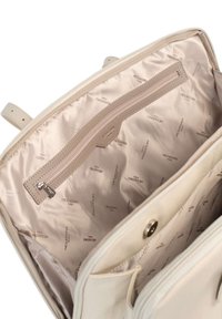 Interno di una borsa a tracolla in pelle beige con tasca con zip e rivestimento liscio con motivo ripetuto del logo Hexagona. Design minimalista e forma strutturata.