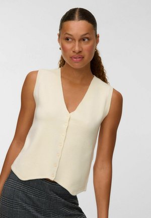 Cream sleeveless vest with a v-neckline, featuring a button-up front and a textured finish. The hem is slightly curved.