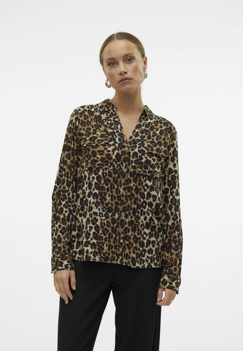 Hedvábná blůza s leopardím vzorem, dlouhými rukávy, klopovým výstřihem, dvěma kapsami na hrudi a knoflíkovým zapínáním. Lehká tkanina s hladkým povrchem.