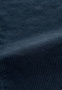 Getextureerd donkerblauw stof met een verticale ribbelpatroon. Zachte oppervlakte, dik materiaal geschikt voor bekleding of kledingtoepassingen.