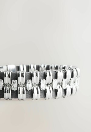 Brățară cu ton argintiu, cu inele alternate lucioase și mate, având cristale transparente rectangulare încorporate pe o bandă netedă de culoare gri închis.