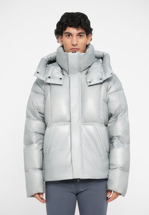 Metallic silver puffer jacket with a high collar, large hood, and snap buttons; features boxy design and quilted texture.