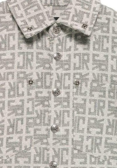 Camicia grigia a fantasia con design a logo ripetuto, chiusura frontale con bottoni e colletto strutturato con dettagli hardware decorativi.