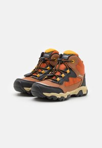 Bottes de randonnée marron et orange avec des accents noirs, tige en tissu texturé, lacets jaunes et semelles en caoutchouc robustes pour une adhérence optimale.