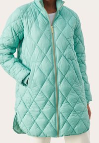 Lichte teal gewatteerde lange jas met ruitpatroon, gouden rits, zijzakken, hoge kraag en iets langere achterkant.