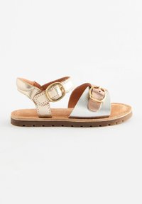Sandal in oro e argento metallici con cinturini regolabili e suola marrone, caratterizzato da una tomaia in pelle texturizzata e un dettaglio con fibbia.