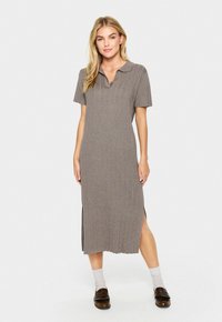 Grå randig midiklänning med korta ärmar, polo-krage, sidofrackar och ett mjukt, texturerat tyg, kombinerad med bruna loafers och ljusa strumpor.