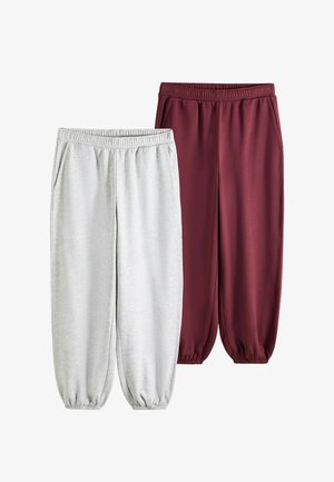 Zwei Paar Jogginghosen mit elastischem Bund und Seitentaschen, eines hellgrau und eines dunkelrot, auf weißem Hintergrund dargestellt.