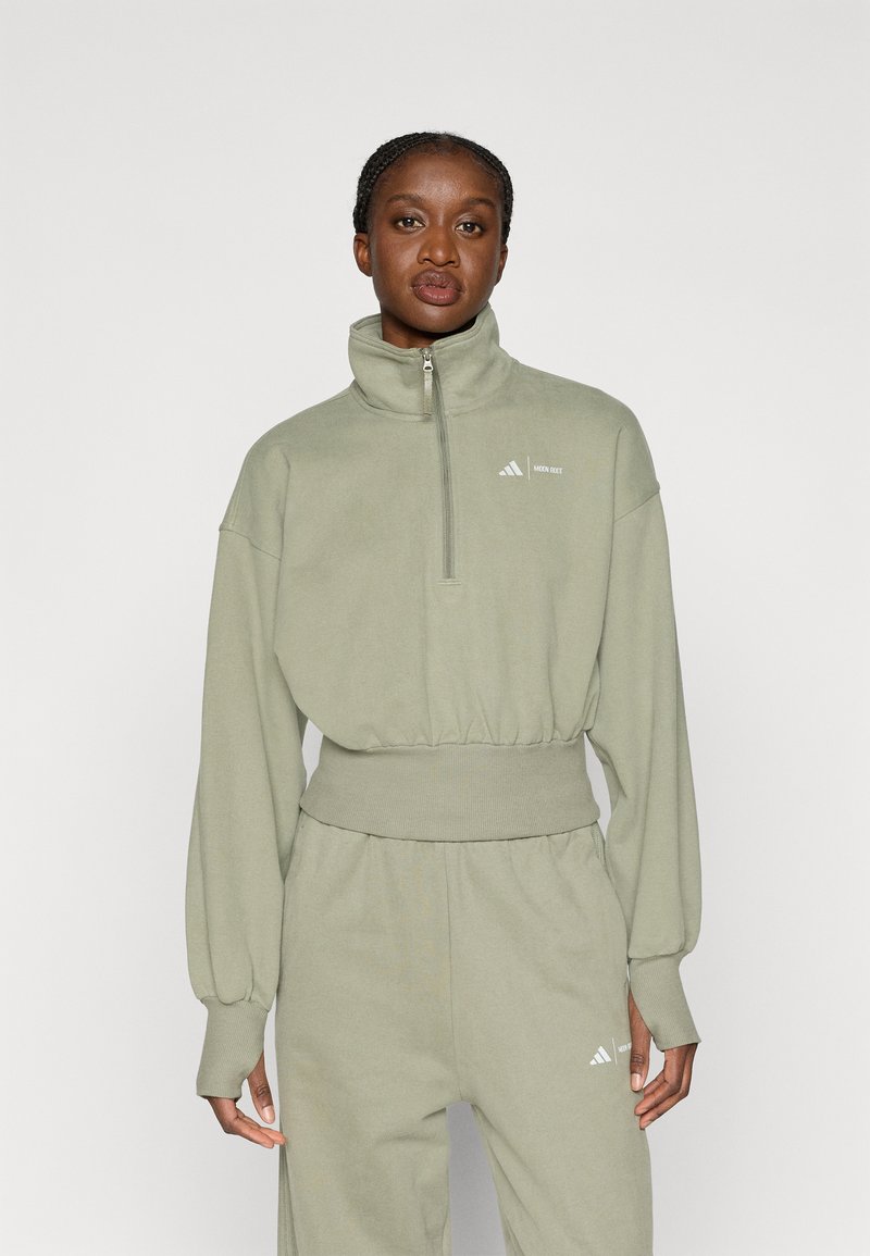 Φωτεινό πράσινο φούτερ με ψηλό γιακά, κλείσιμο με φερμουάρ και ελαστική μέση; διαθέτει διακριτική branding σε λευκό στο στήθος.