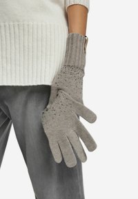 Grå stickade handskar med en strukturerad yta och prydda med små klara detaljer, med en åtsittande design som täcker handleden.