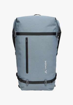 Mochila rectangular azul claro con bolsillo delantero vertical con cremallera, correas horizontales negras y logotipo VAUDE en la parte delantera.