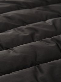 Fekete steppelt paplan sima textúrával, kiemelkedő részekkel és enyhén fényes felülettel, egységes varrással.