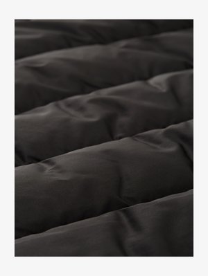 Črni spalni odeja s prešito teksturo, gladkim občutkom, z dvignjenimi deli in rahlo svetlečim zaključkom, z enakomernim vzorcem šivi.