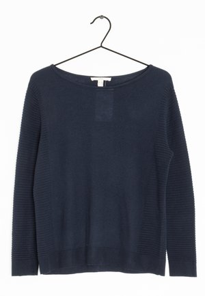 Marineblauwe trui met lange mouwen, voorzien van geribbelde mouwen en zoom, hangend aan een zwarte metalen hanger tegen een witte achtergrond.