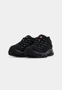 Black hiking shoes with textured mesh and synthetic upper, featuring gray laces and rugged rubber soles with distinct tread patterns.