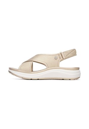 Sandalia de cuero dorado con diseño de tiras cruzadas, punta abierta y correa ajustable en el tobillo. Suela acolchada blanca para mayor comodidad. Material texturizado.