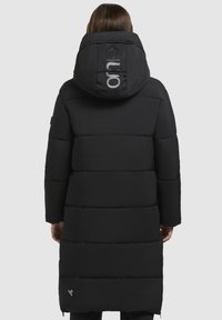 Lang sort pufferjakke med hætte, med en quiltet design, lynlåslommer og et reflekterende logo på ryggen. Glat tekstur.