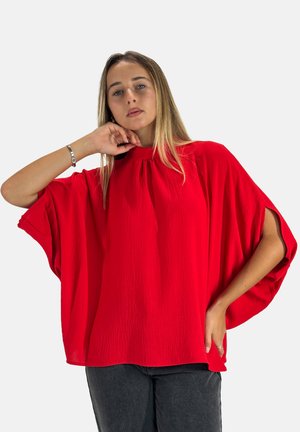 Rode blouse met korte mouwen, ronde hals en geplooide details. De stof is lichtgewicht en textuur, met een losse pasvorm en zijsplitten.