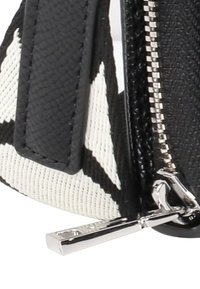 Czarna torba wykonana z fakturowanego materiału z kontrastowymi białymi wzorami geometrycznymi, srebrnym zamkiem błyskawicznym i eleganckim designem.