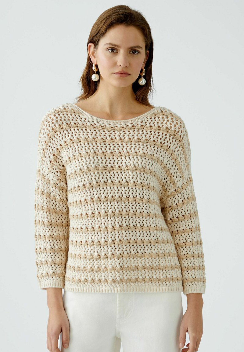 Beige und creme gestreifter Strickpullover mit einer lockeren Passform, featuring einem weiten Ausschnitt und strukturiertem offenem Gewebe. Lange Ärmel, gerippter Saum.