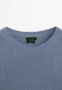 Pull en coton tricoté bleu clair avec col rond côtelé et étiquette de marque cousue à l'intérieur du col.
