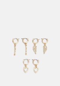 Brincos de argola dourados com vários desenhos: um apresenta as letras "AMOR", outro com formas de chama, e um pendente em forma de coração.