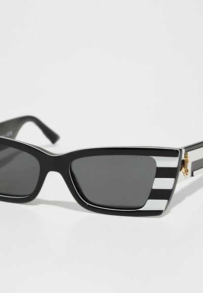 Black rectangular sunglasses with dark lenses, featuring striped white and black temple arms and gold accents. Made from a glossy material.