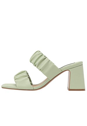 Zielone sandały na obcasie z ekoskóry z dwoma marszczonymi paskami, kwadratowym otwartym czubkiem i masywnym obcasem. Płaska podeszwa i gładka faktura.