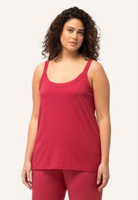 Red sleeveless top made of soft fabric, featuring a scoop neckline and wide straps, paired with matching red pants.