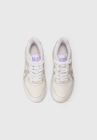 Ζεύγος λευκών αθλητικών παπουτσιών Asics με ανοιχτό πράσινες λεπτομέρειες και μωβ branding, απεικονιζόμενα από πάνω σε λευκό φόντο.