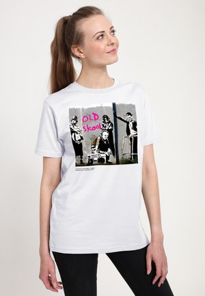 Weißes Baumwoll-T-Shirt mit einem Grafikdruck von vier Figuren und dem Text "OLD skool" in Pink auf einem grauen Hintergrund.