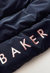 Námorná puffrová bunda z látky s hladkou textúrou a lesklým povrchom, s veľkým ružovým zlatým nápisom "BAKER."