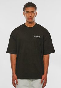 Black oversized t-shirt made of cotton, featuring a small white "Dropsize" logo on the front. Smooth texture and relaxed fit design.