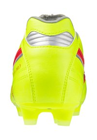 Botín de fútbol amarillo con acentos en rojo y plateado, que presenta una parte superior de cuero liso, un cuello acolchado y tacos moldeados para mayor tracción.