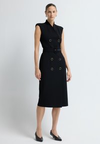 Czarna sukienka bez rękawów z podwójnym zapięciem z przodu, złotymi okrągłymi detalami, dopasowanym paskiem w talii i spódnicą do kolan, o gładkiej fakturze materiału.