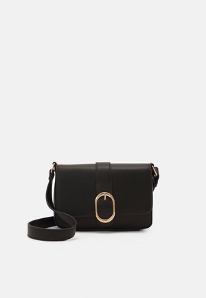 Bolso bandolera rectangular negro con hebilla ovalada dorada y correa ajustable sobre un fondo liso y claro.