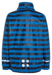 Sinivalkoraidallinen sadetakki, jossa pieniä neliökuvioita ja heijastavia pisteitä takana alaosassa. Kuminauhalla varustetut hihansuut, joissa heijastavat raidat.