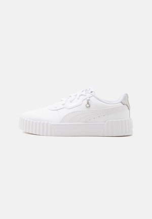 Sneakers basses blanches avec semelle épaisse à rainures, breloque en forme d'étoile sur les lacets et marquage brodé discret sur le côté.