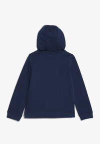 Sudadera azul marino hecha de una tela suave y texturizada, con una capucha redondeada, mangas largas y un dobladillo recto con detalles de costura mínimos.
