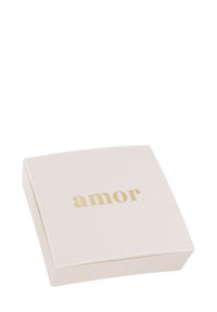 Kwadratowe, kremowe pudełko o gładkiej fakturze. Na wieczku znajduje się złoty napis "amor". Prosty, elegancki design.