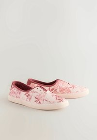 Zapatillas de lona con estampado floral en rosa claro con acentos en rosa oscuro. Presentan aberturas elásticas, suelas de goma blanca y tres ojetes.